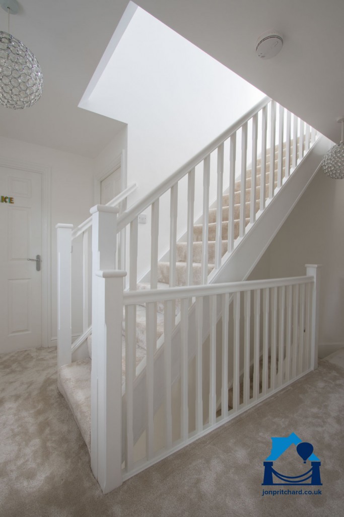 Portrait orientation photo of a generous staircase leading from a spacious first floor landing to a fully integrated loft coversion.